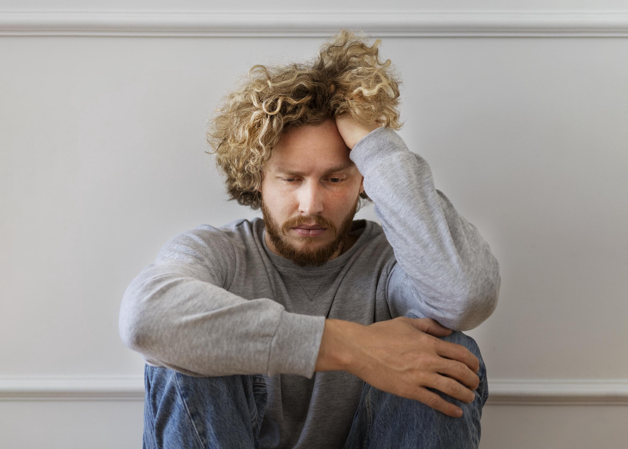 Primer plano de un hombre enfadado con un jersey gris | Fuente: Freepik