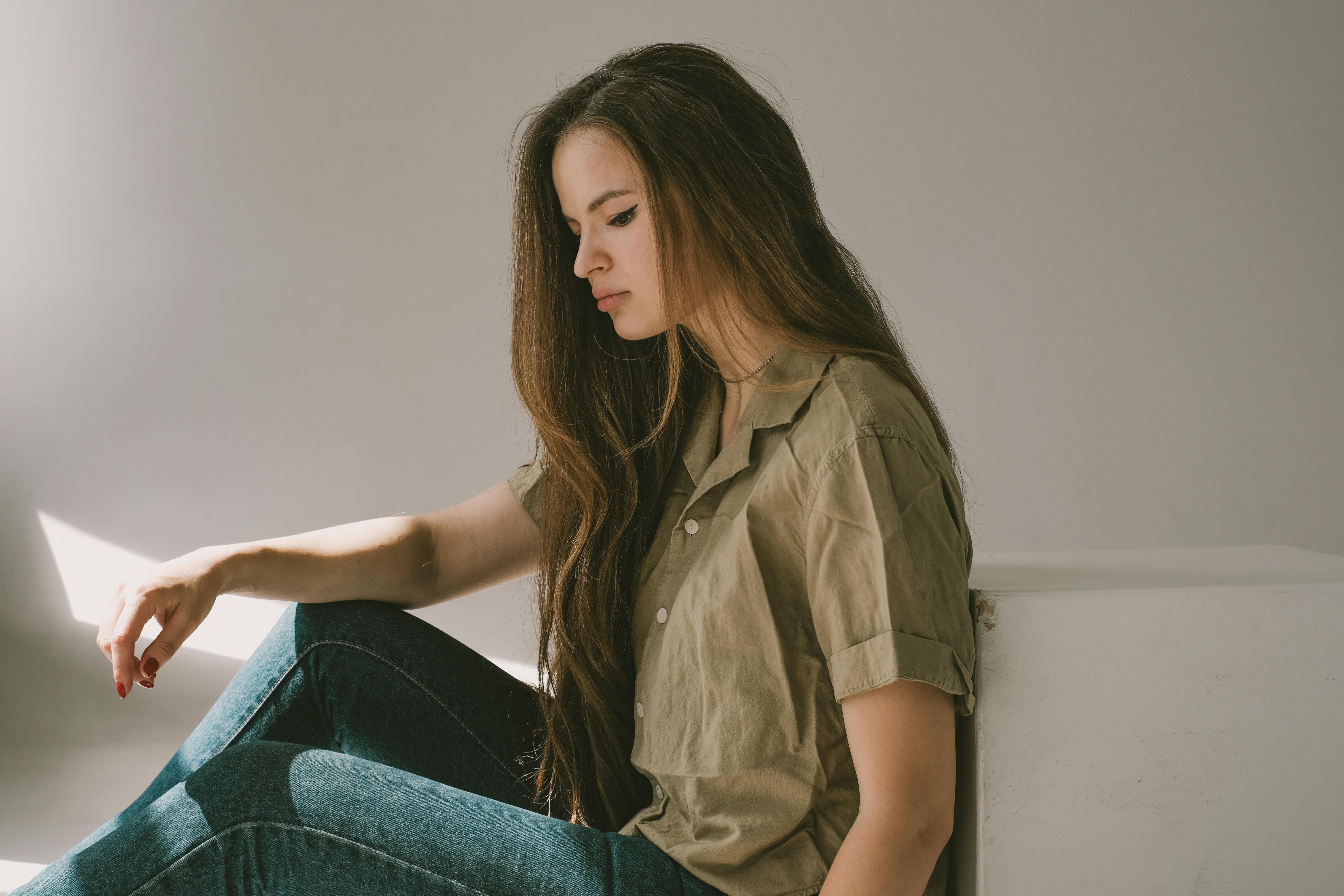 Mujer triste sentada en el suelo | Fuente: Pexels
