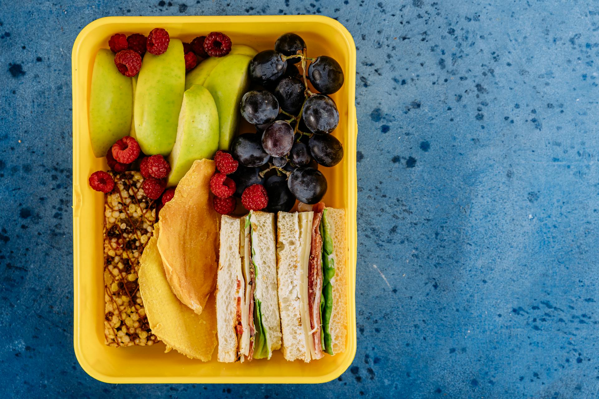 Una lonchera con bocadillos y fruta | Fuente: Pexels