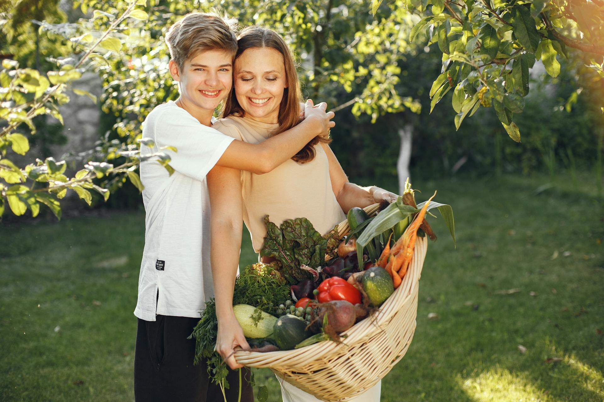Un niño abrazando a su madre en el jardín | Fuente: Pexels