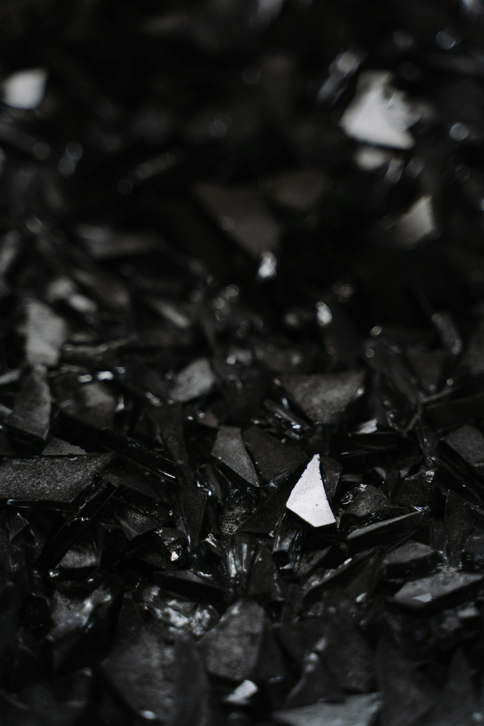 Una foto en escala de grises de trozos de cristal rotos en el suelo | Fuente: Pexels