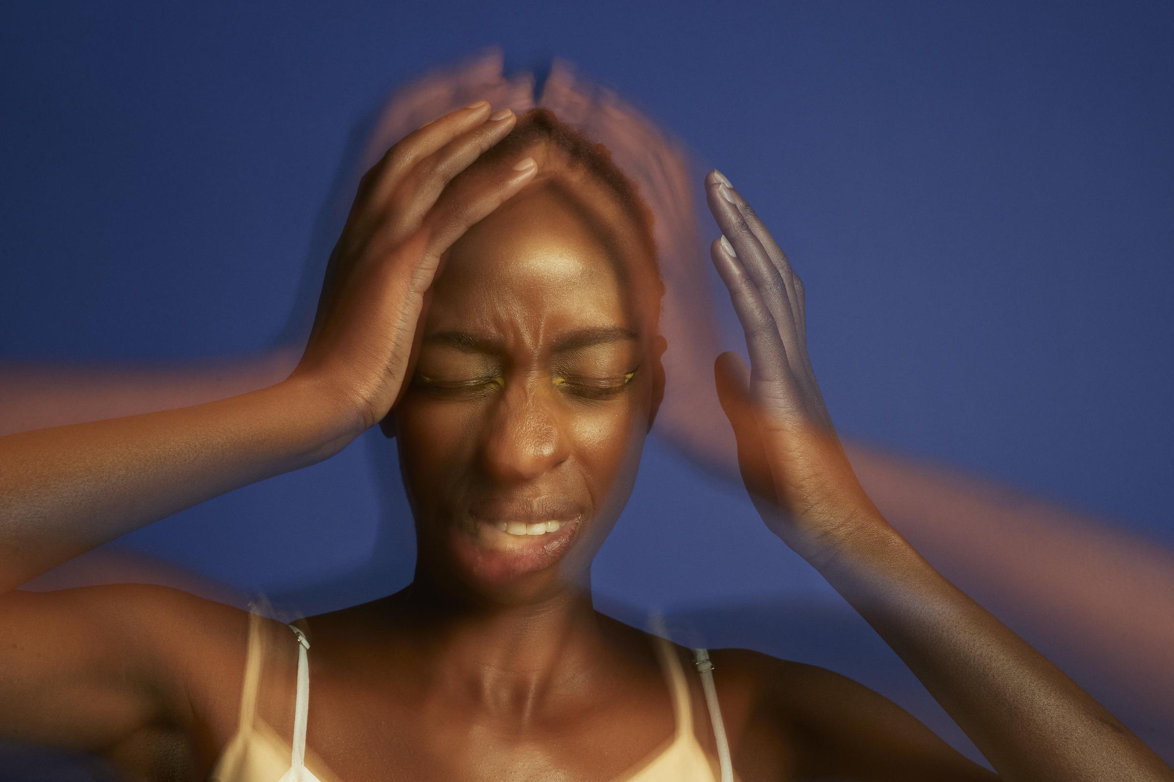 Imagen de exposición múltiple de una mujer joven con dolor de cabeza, sujetándose la cabeza con las manos y los ojos cerrados | Fuente: Getty Images