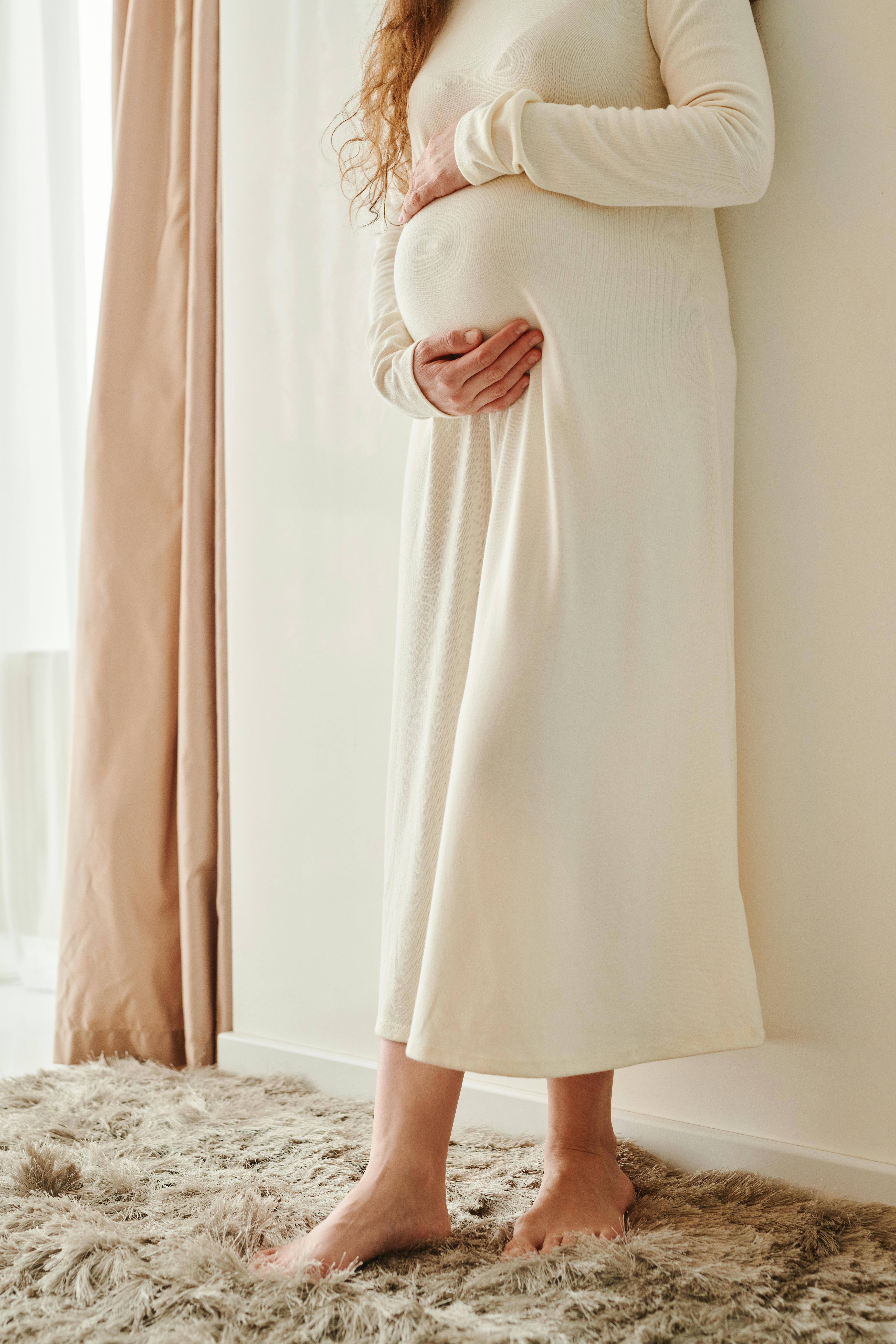 Una mujer embarazada acunando su barriga | Fuente: Pexels