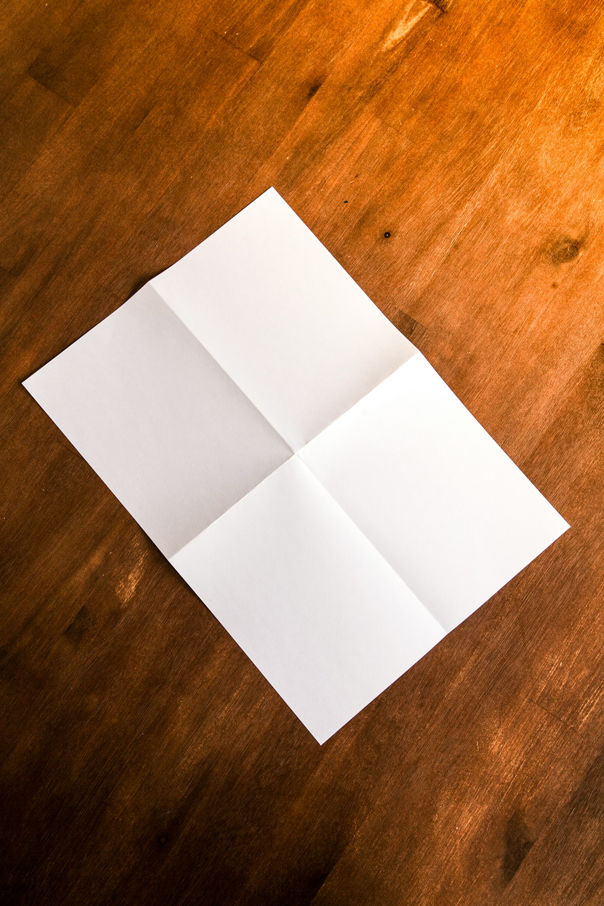 Una hoja de papel sobre una superficie de madera marrón | Fuente: Unsplash