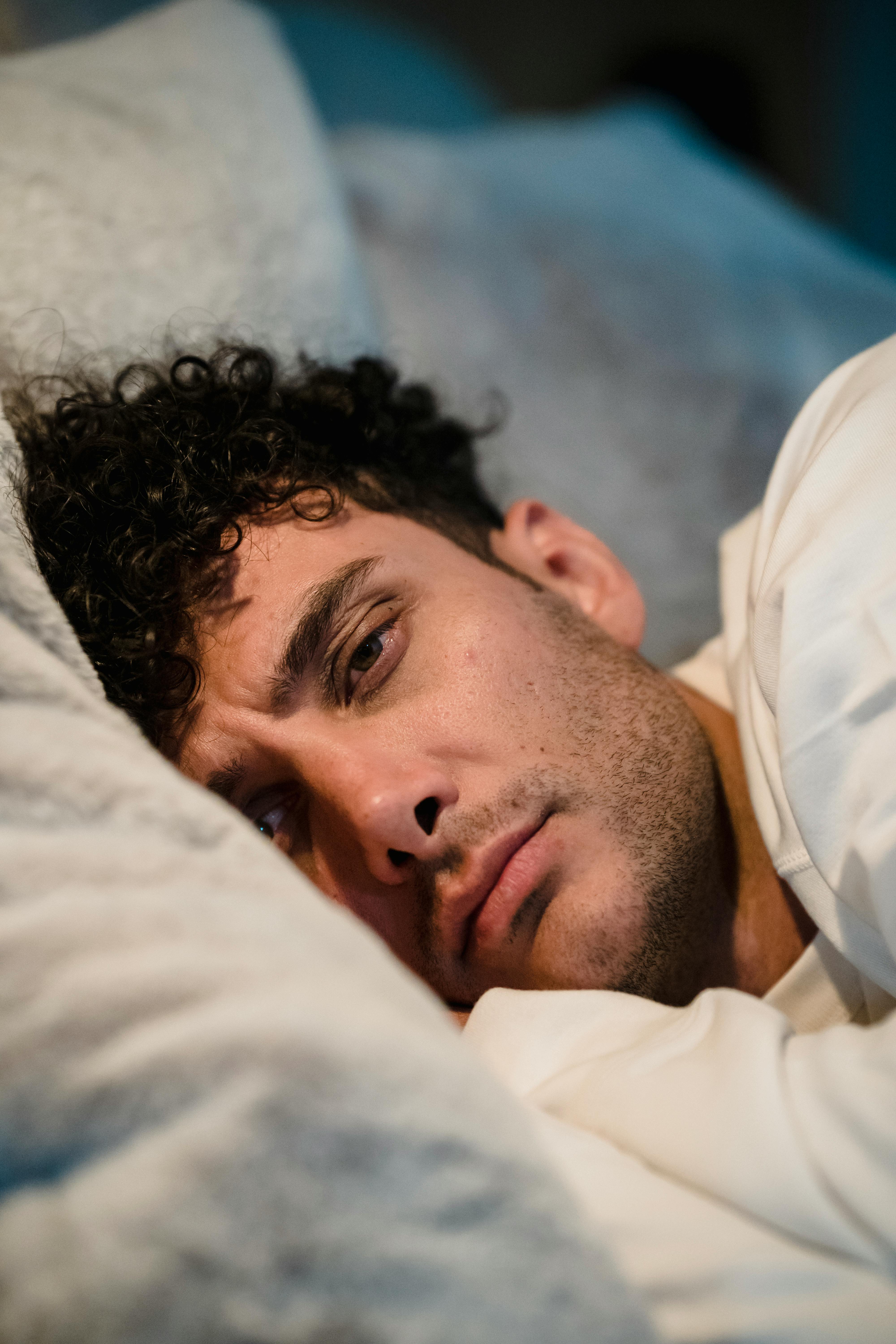 Un hombre molesto tumbado en la cama | Fuente: Midjourney