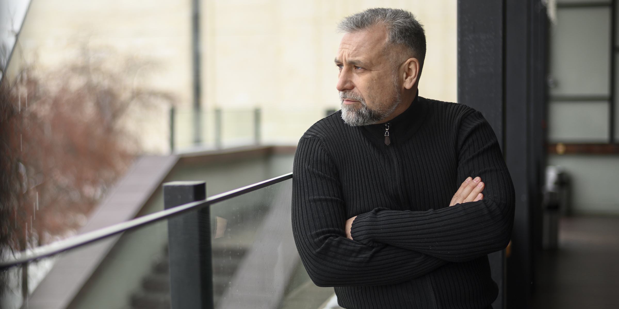 Un hombre severo de pie en un balcón | Fuente: Freepik