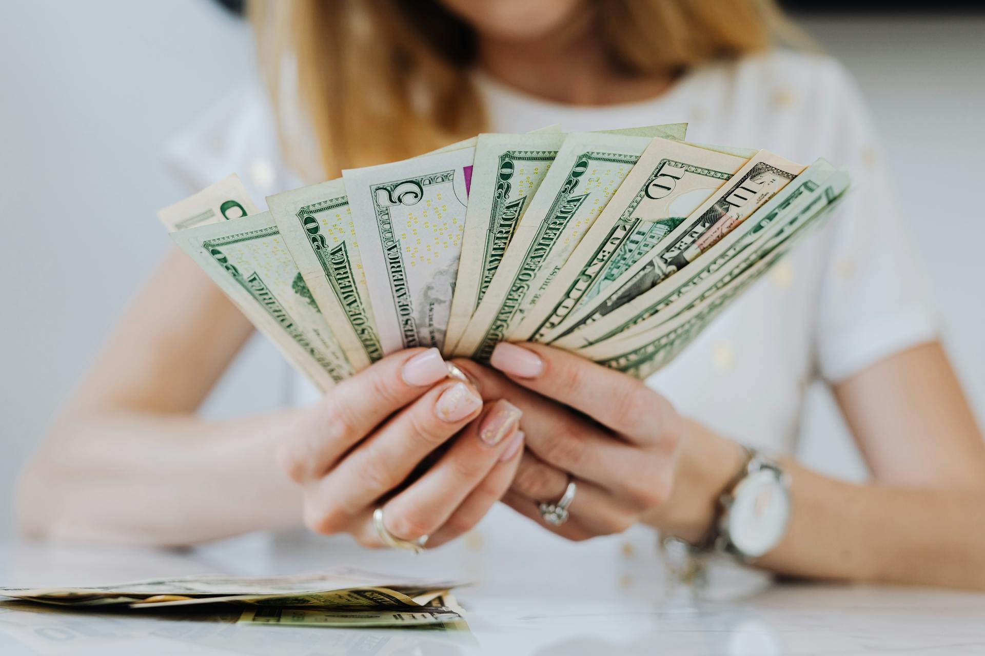 Una mujer con dinero en la mano | Fuente: Pexels