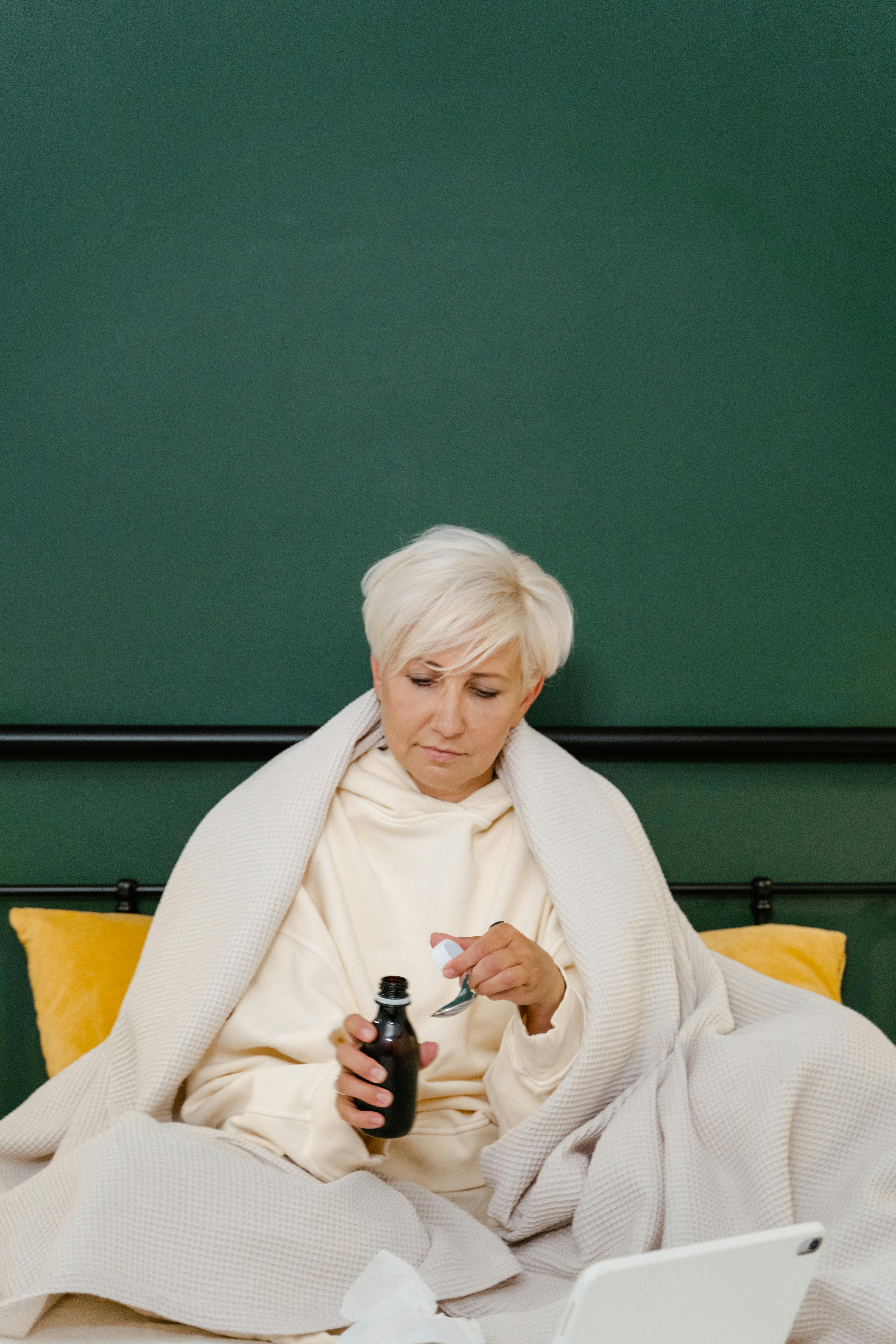 Una mujer hablando de medicina en la cama | Fuente: Pexels