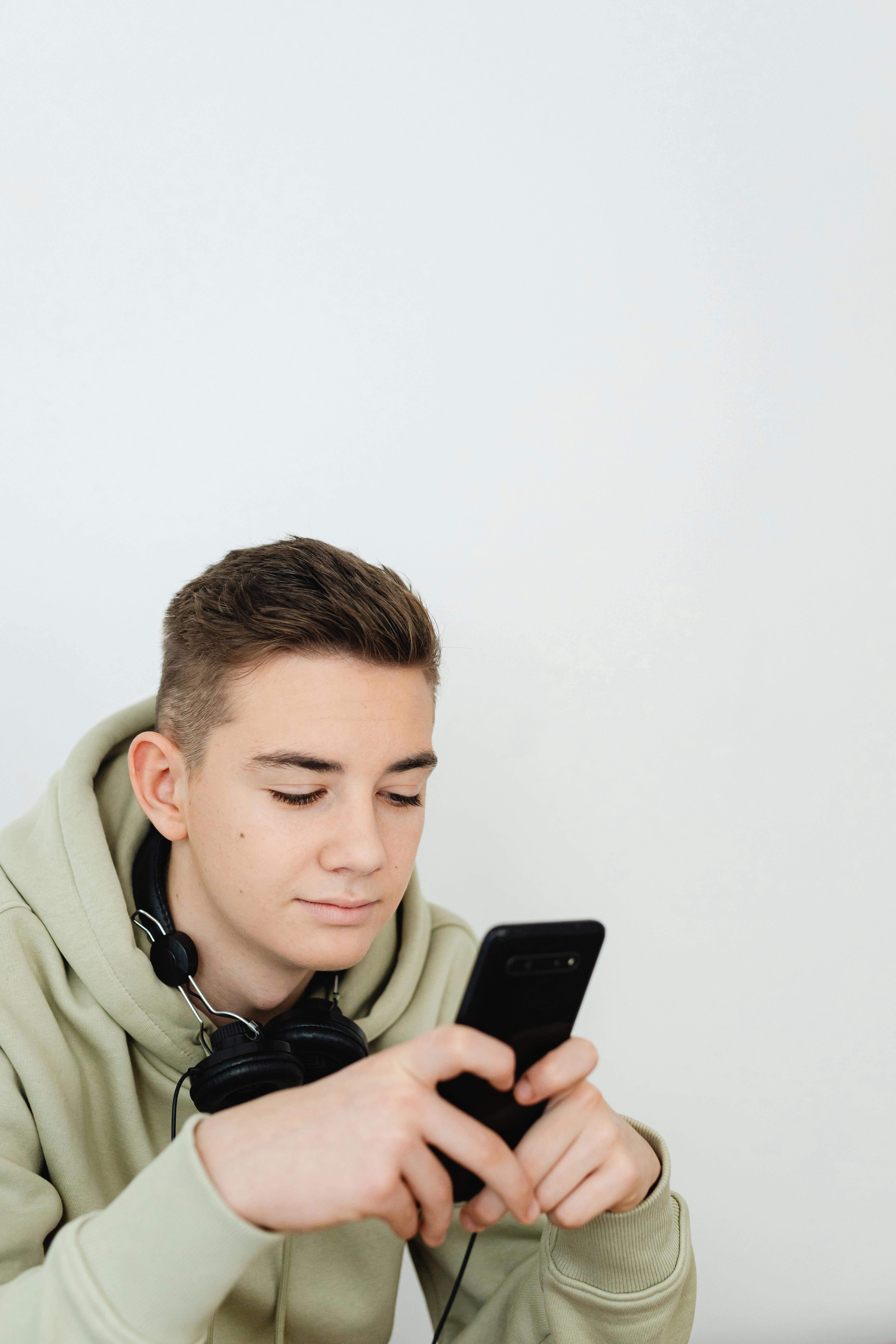 Un adolescente usando un teléfono | Fuente: Pexels