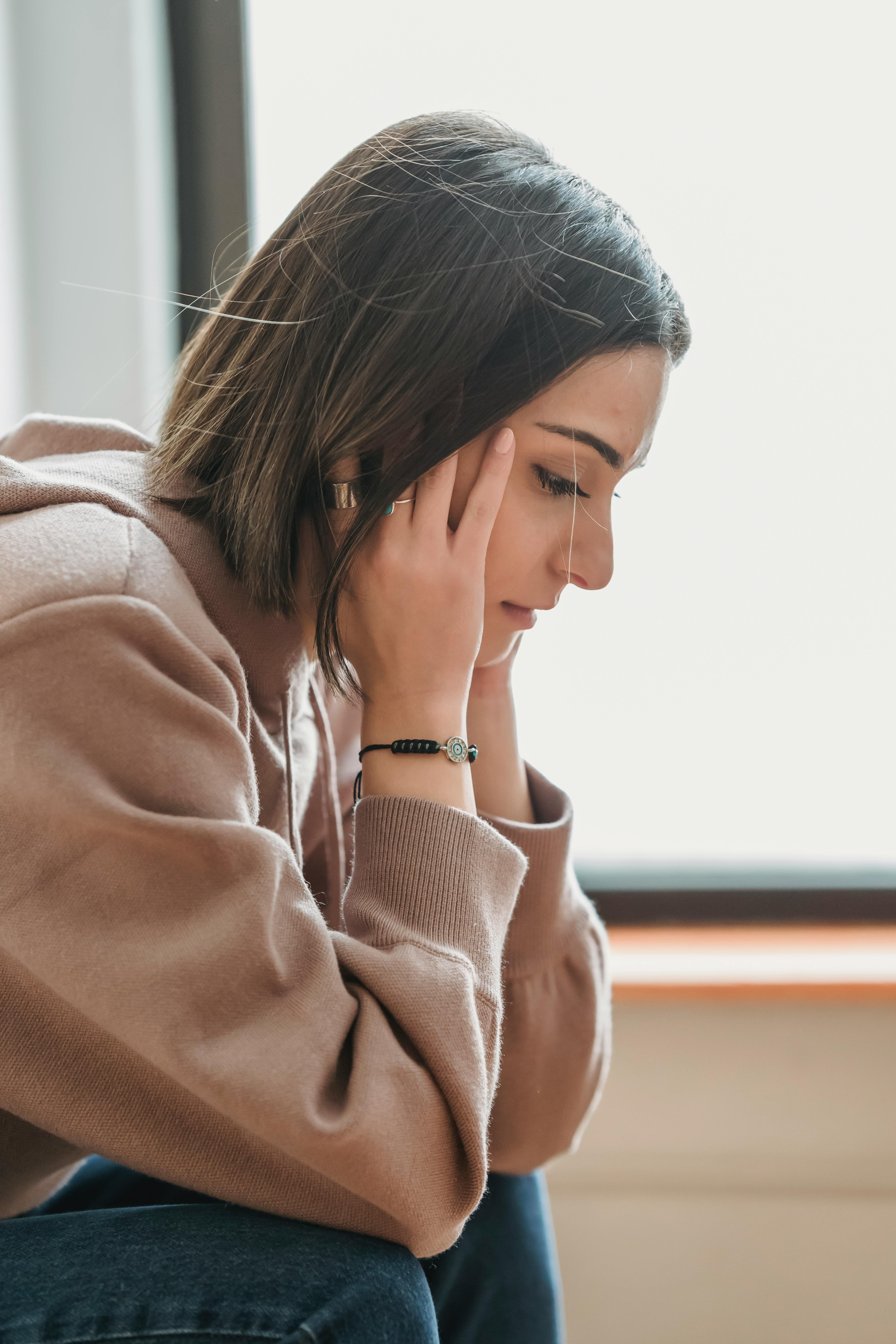 Una mujer mirando hacia abajo | Fuente: Pexels