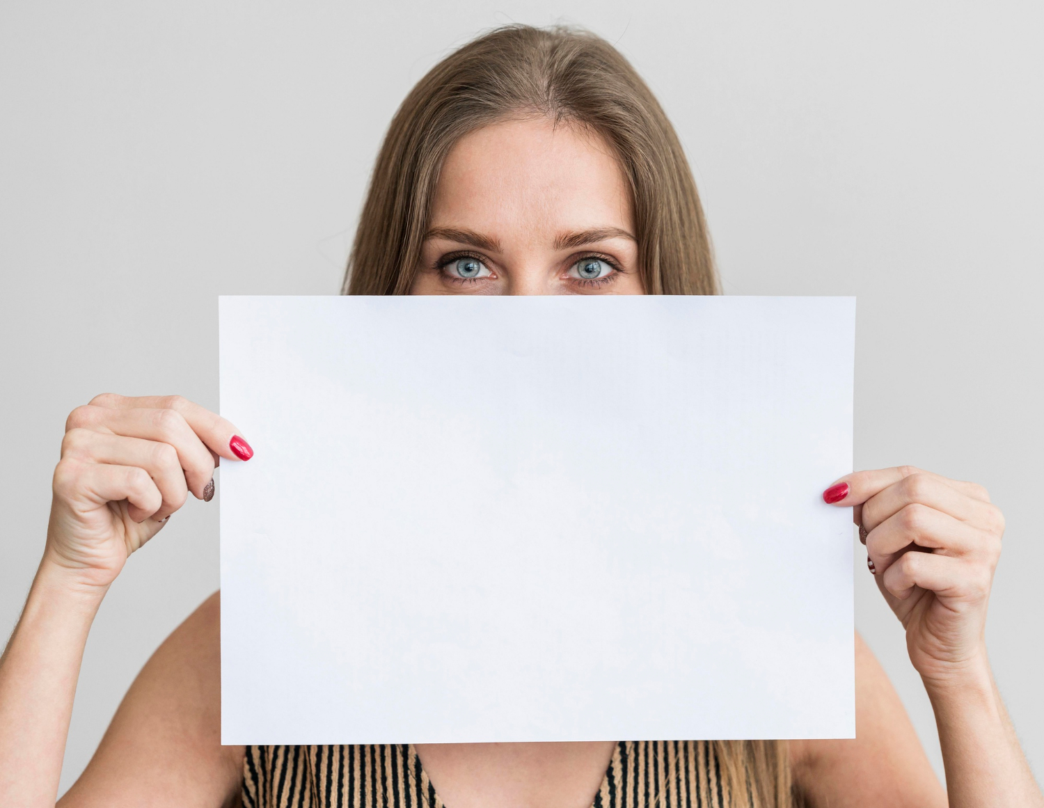 Una mujer sujetando una hoja de papel | Fuente: Freepik