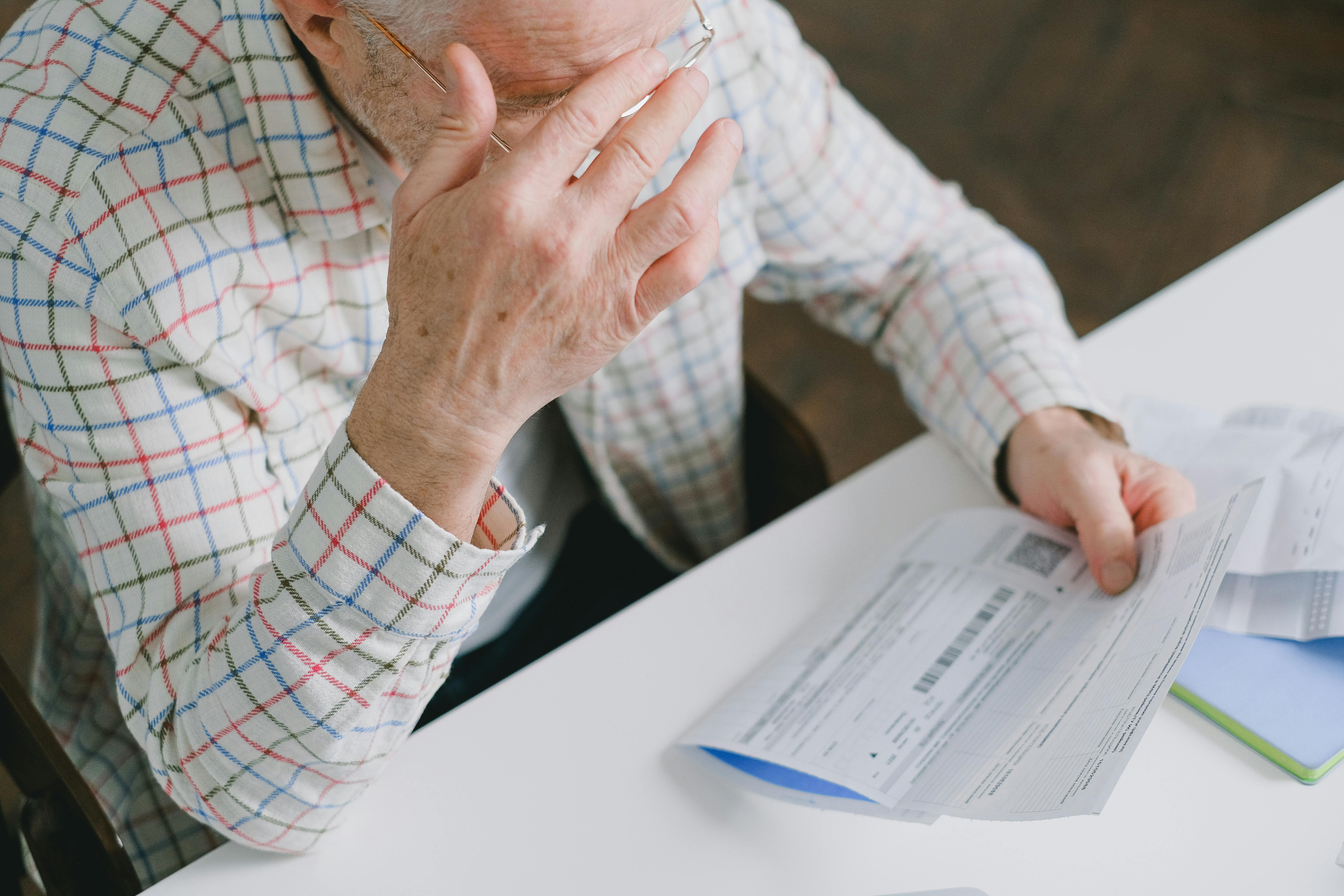 Anciano sujetando un papel | Fuente: Pexels