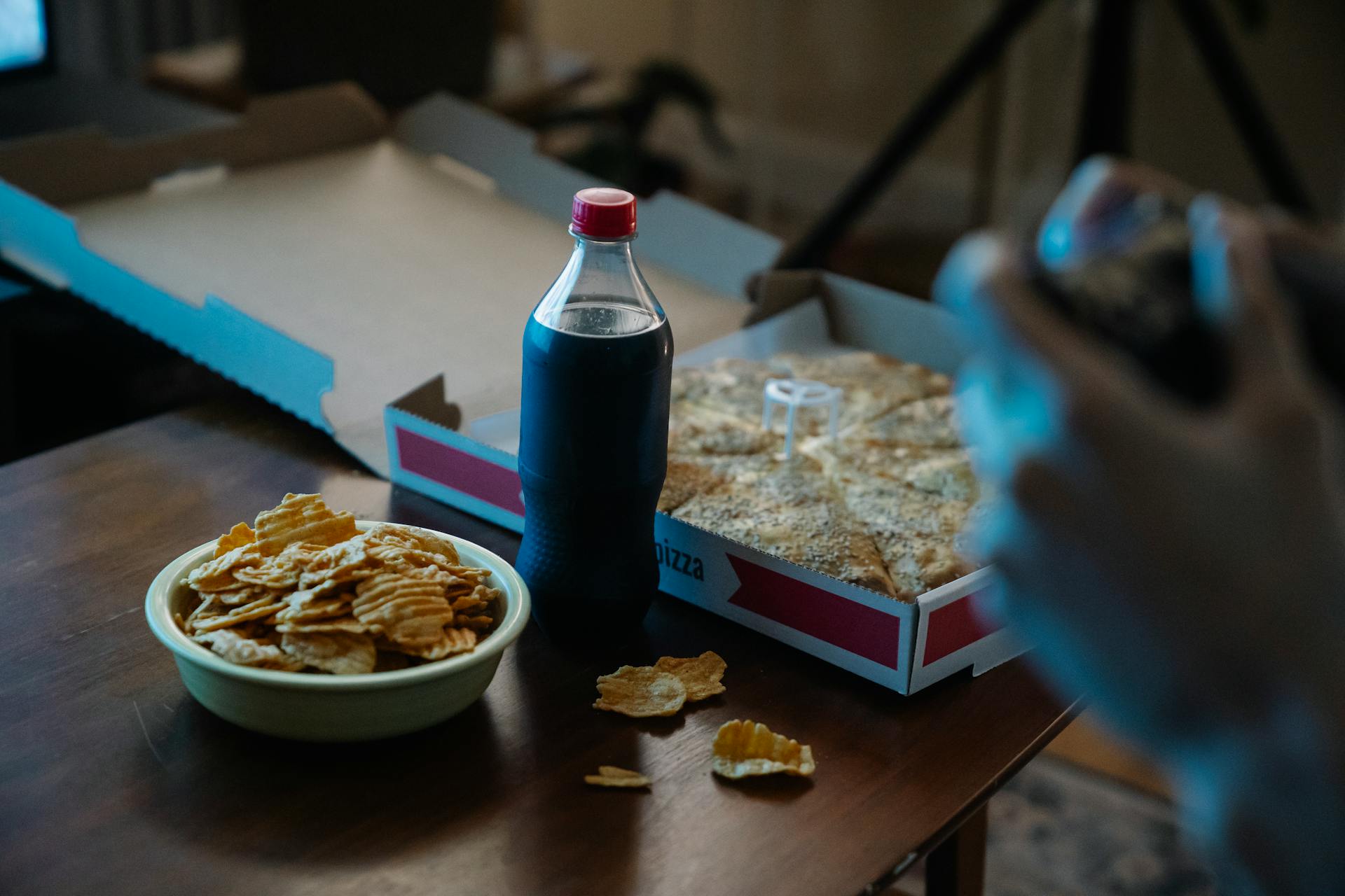 Una persona disfrutando de pizza, refresco de cola y patatas fritas | Fuente: Pexels
