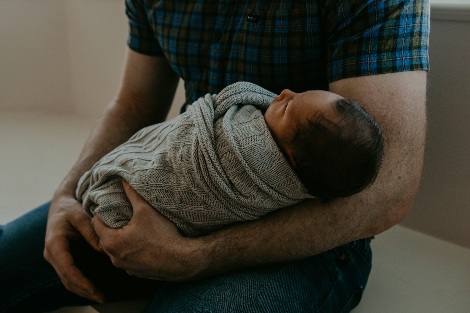 Un hombre con un bebé recién nacido en brazos | Fuente: Unsplash