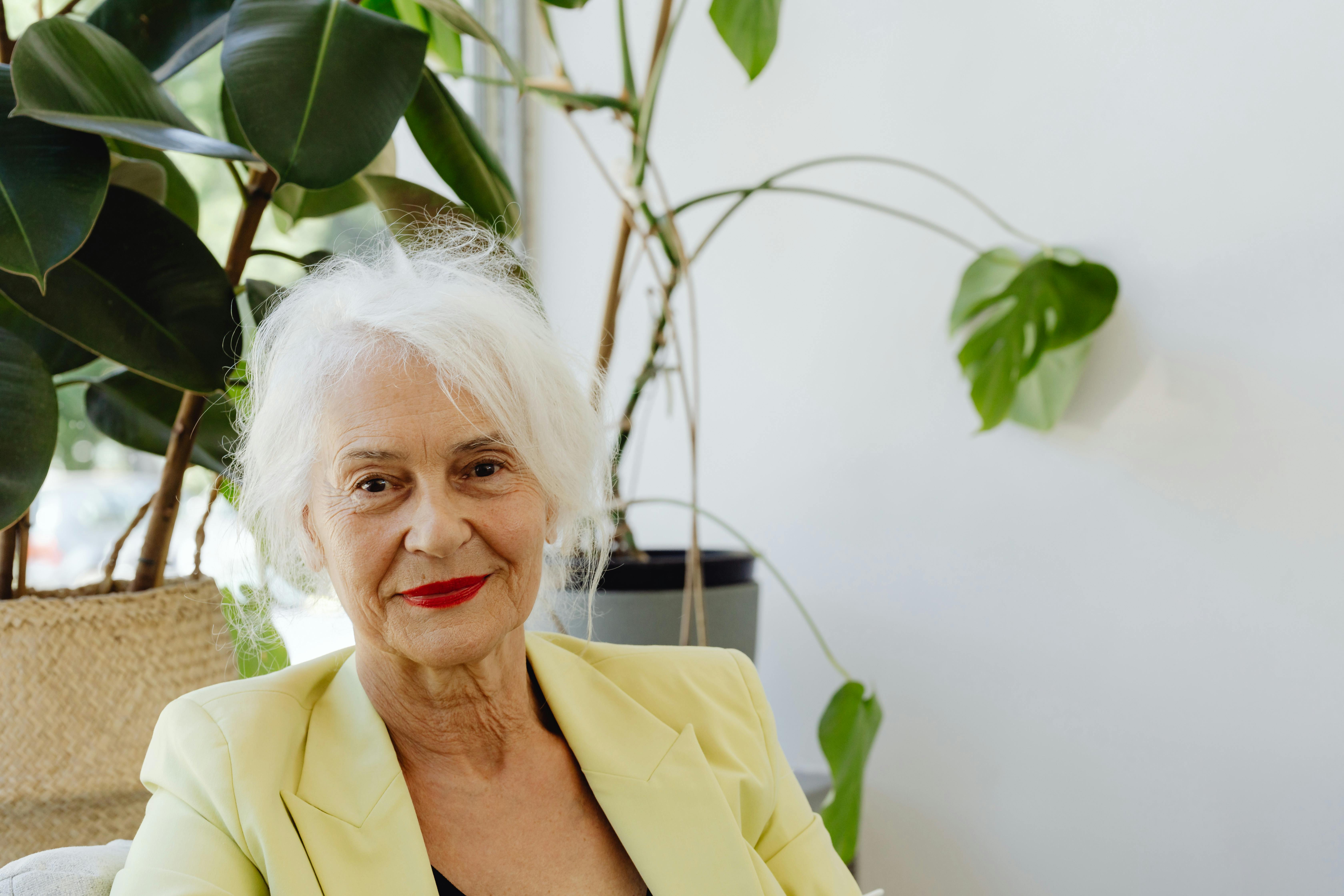 Una anciana sonriente con una americana amarilla | Fuente: Pexels
