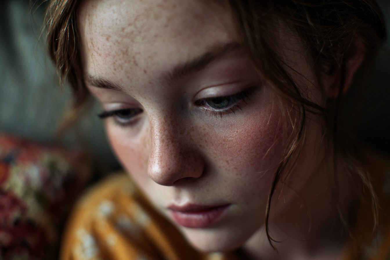 Una chica mirando hacia abajo | Fuente: Midjourney