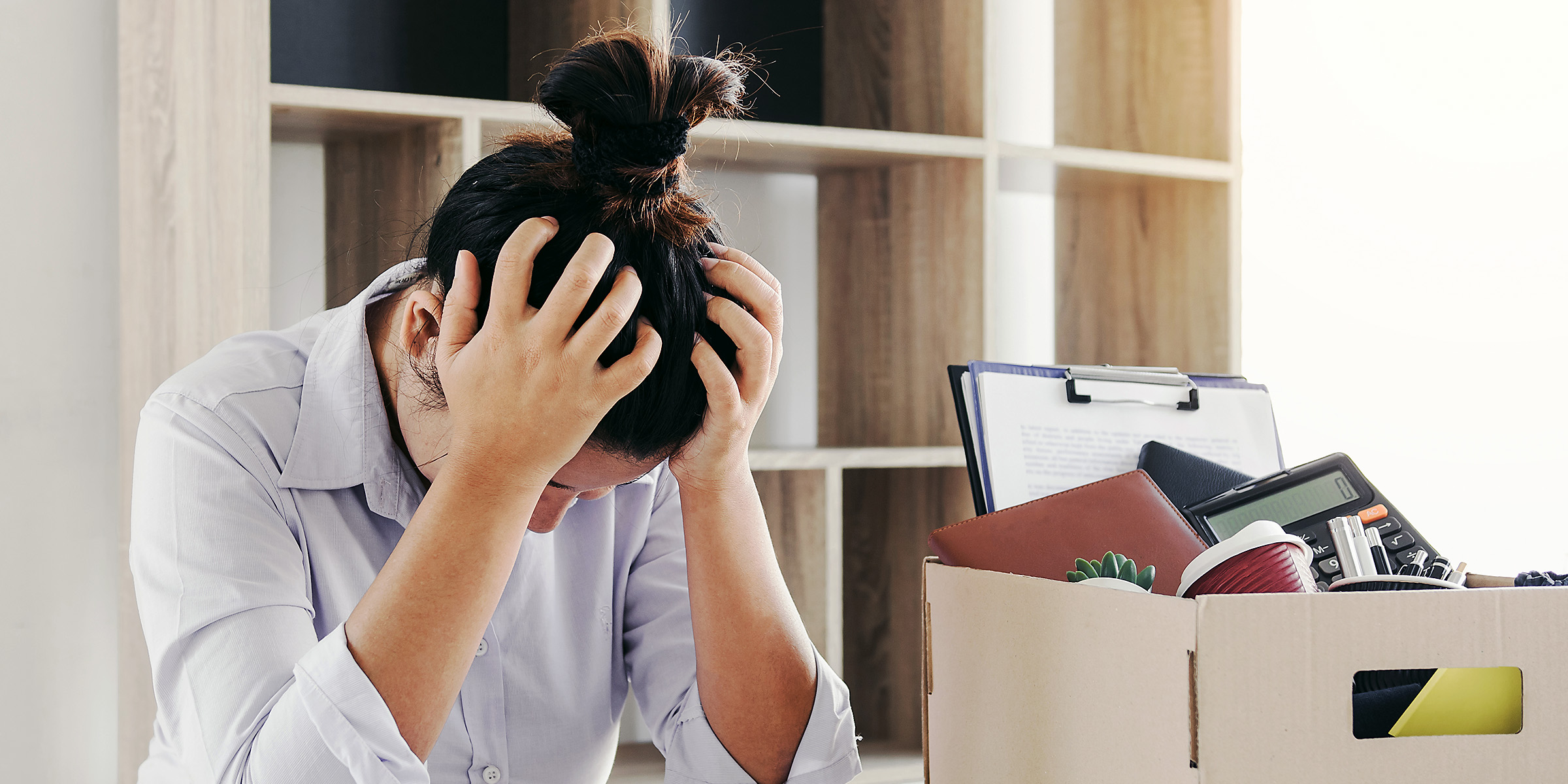 Una mujer estresada sentada en su despacho | Fuente: Shutterstock