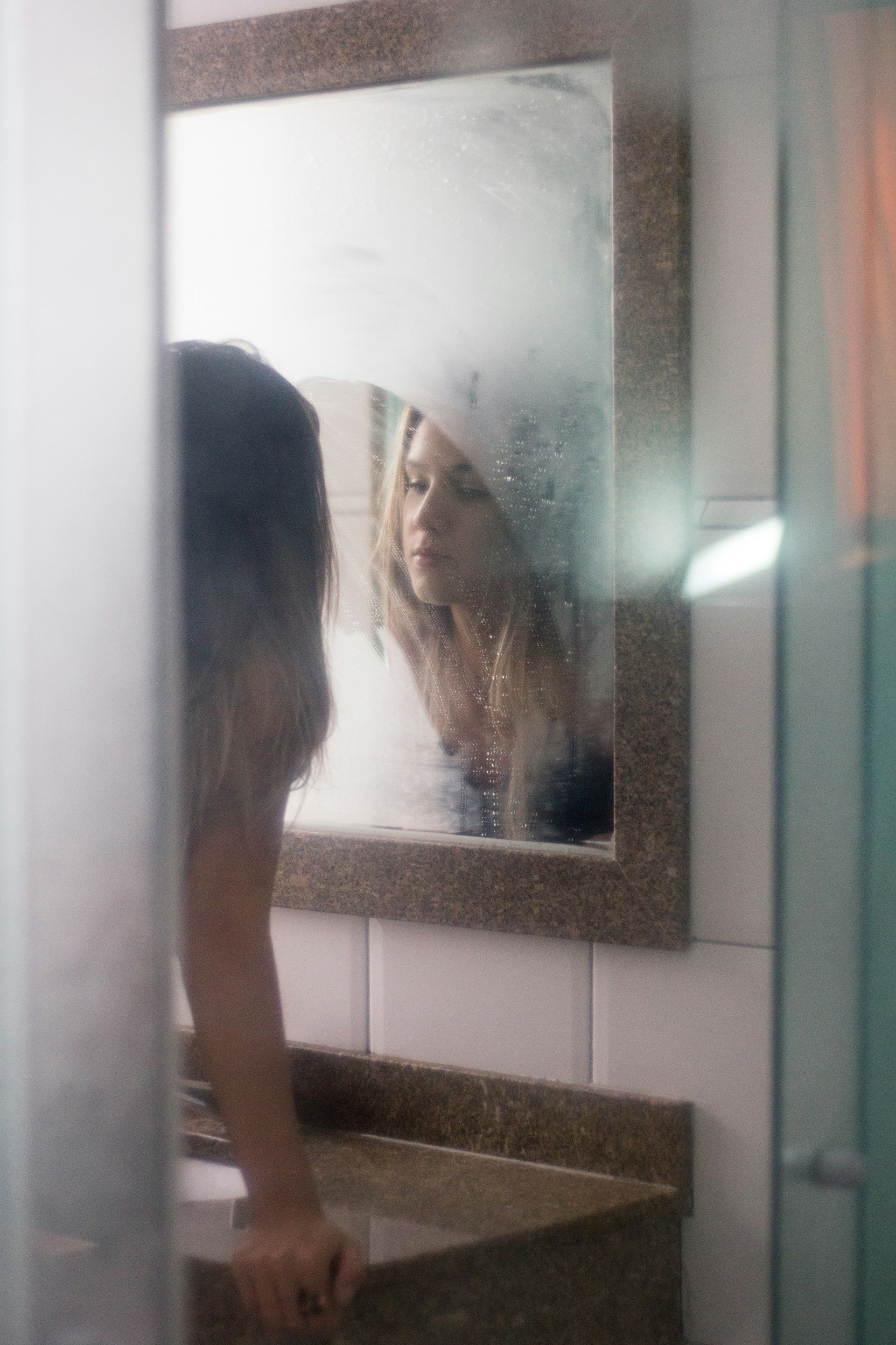 Una mujer mirándose en el espejo del baño | Fuente: Unsplash