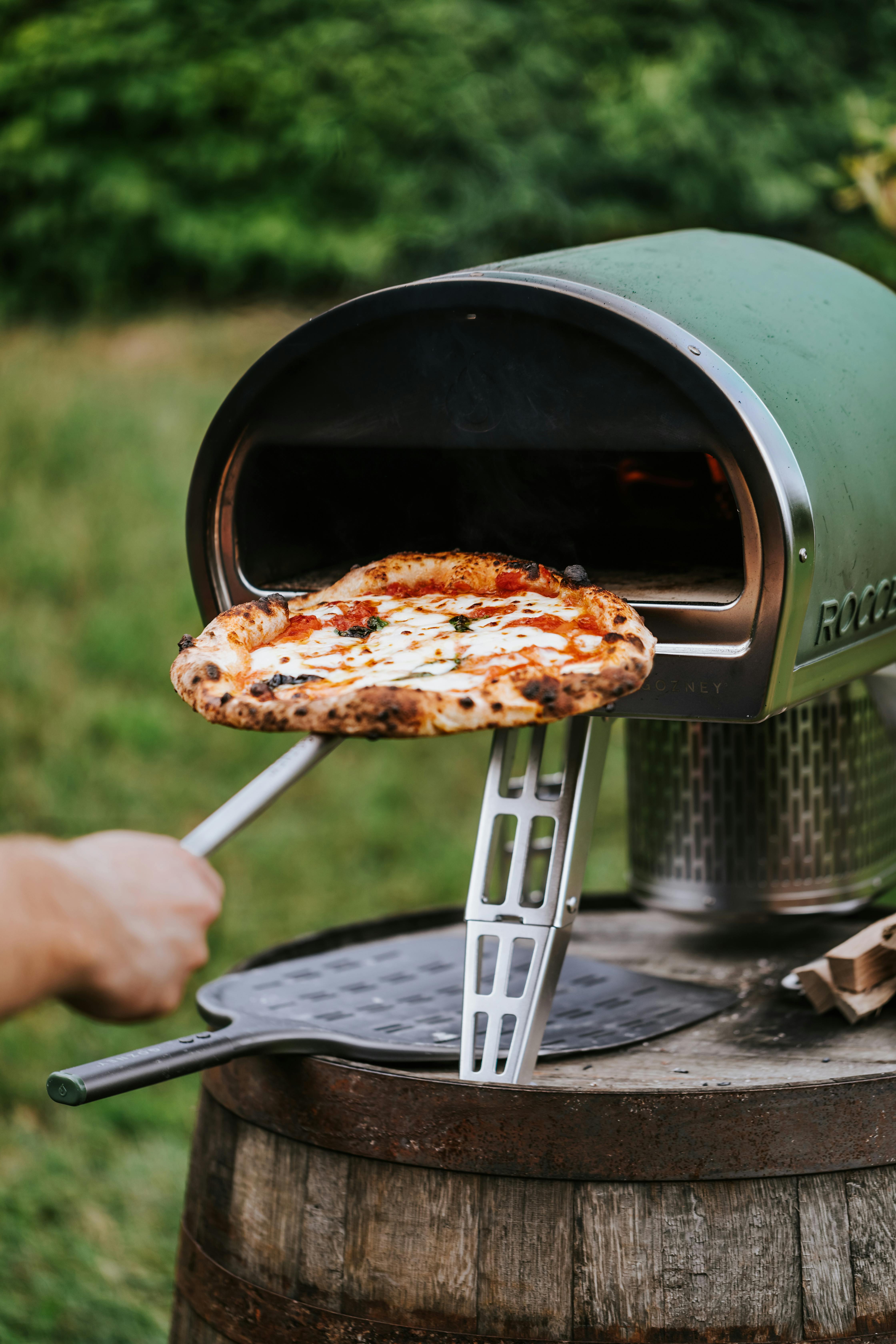 Una persona utilizando un horno de pizza casero | Fuente: Pexels