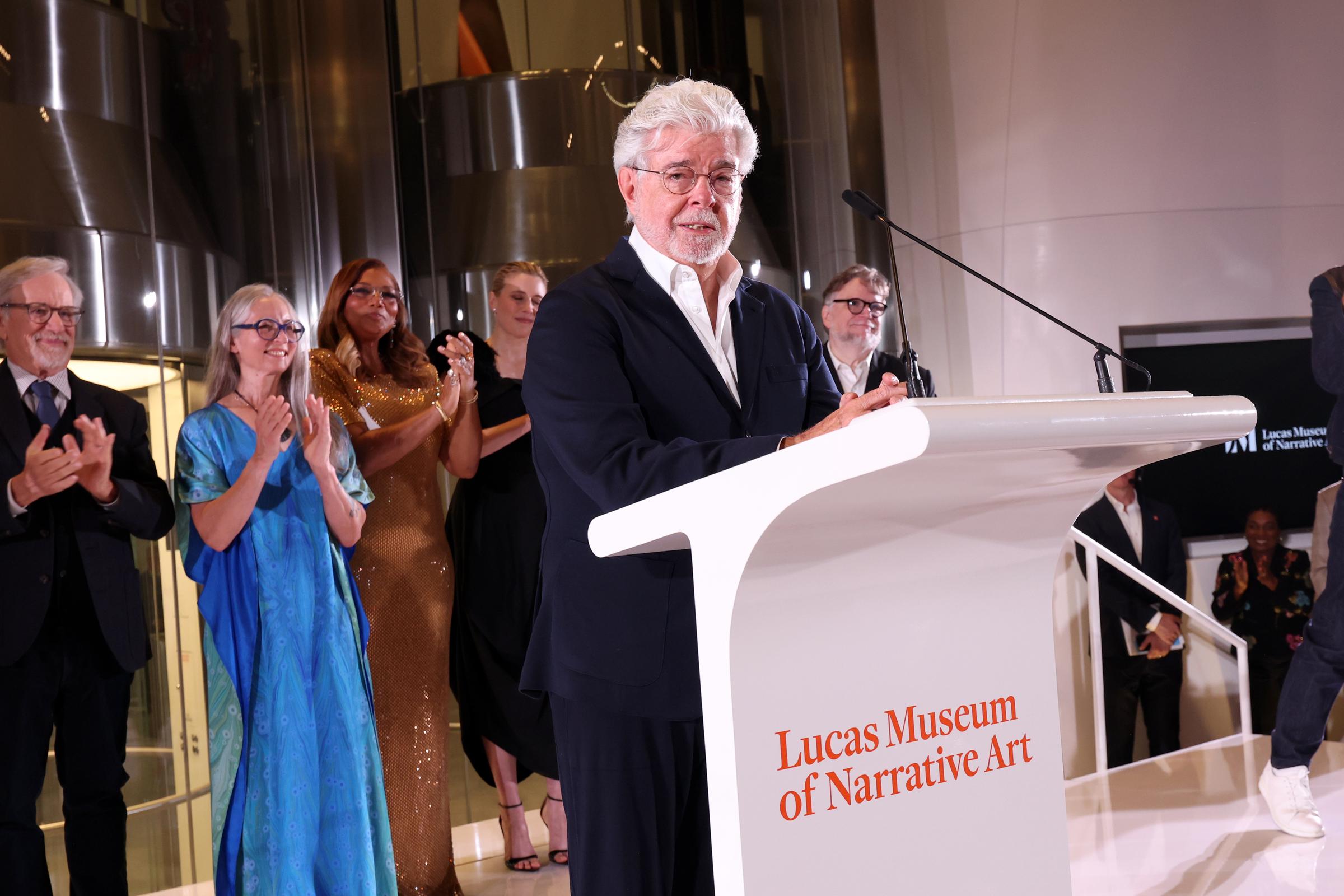 Lucas se dirigió a los invitados desde un estrado en el que se leía el nombre