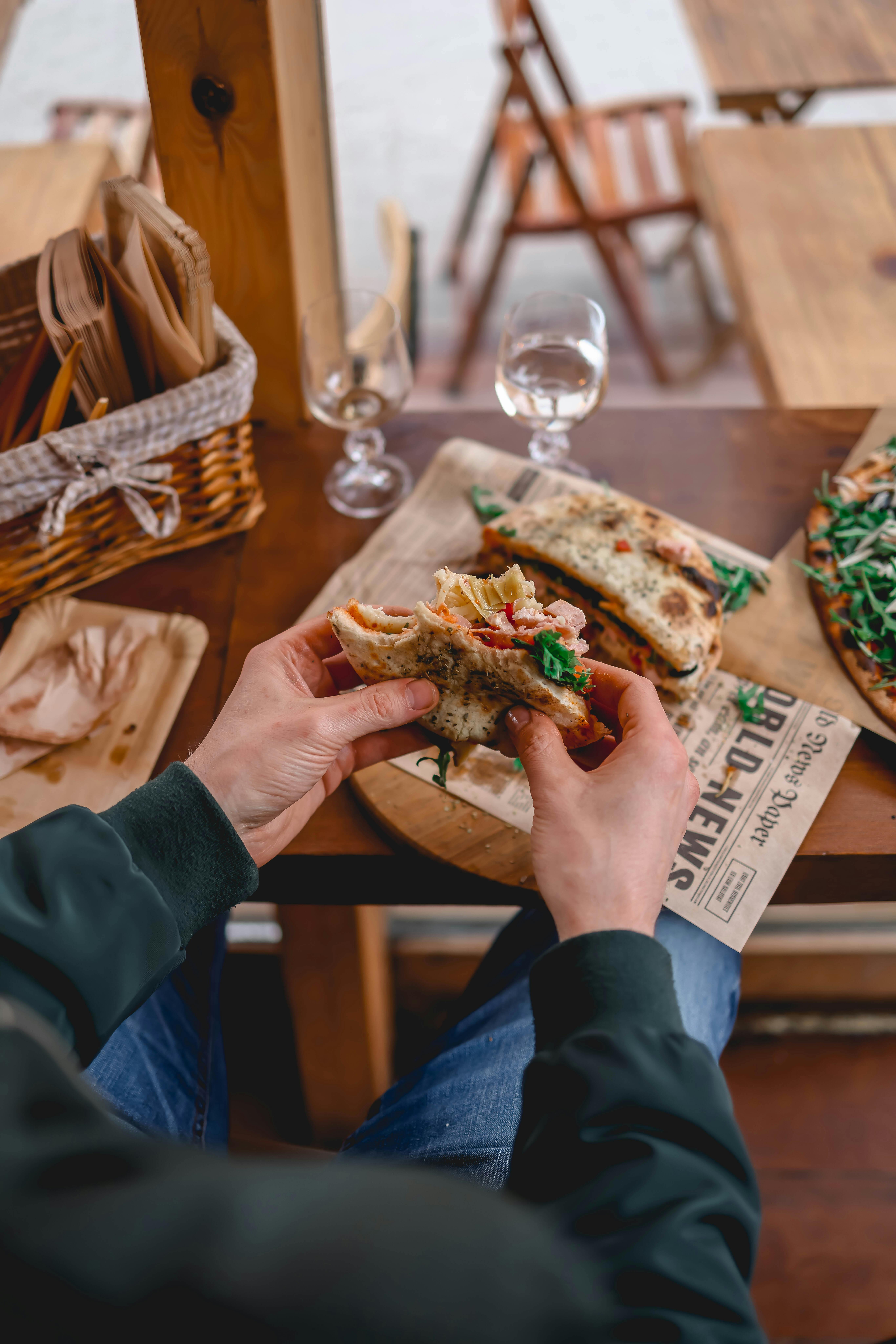 Un hombre con un sándwich a medio comer | Fuente: Pexels