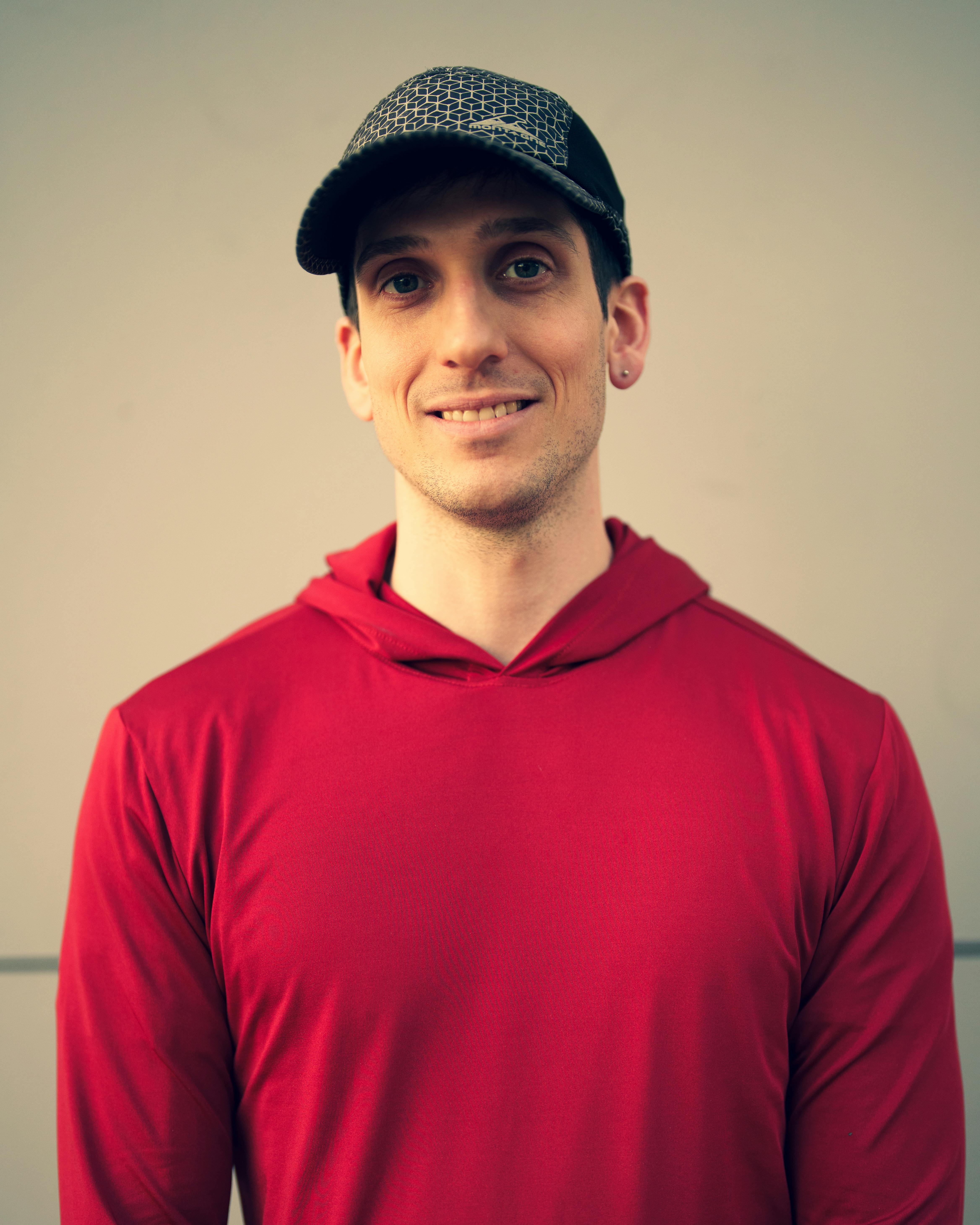 Un hombre sonriente con una sudadera roja | Fuente: Pexels