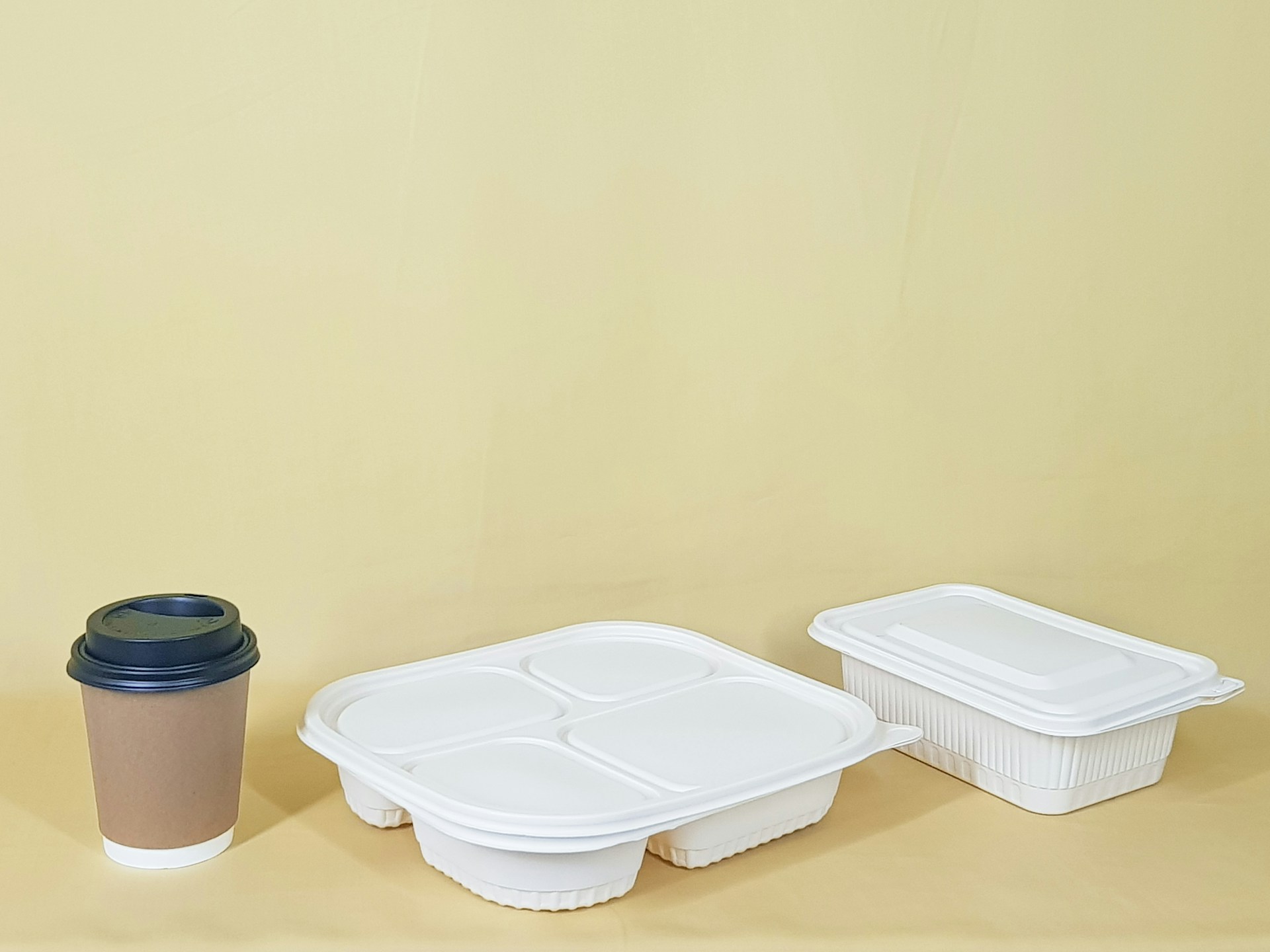 Una taza junto a dos recipientes de comida | Fuente: Unsplash