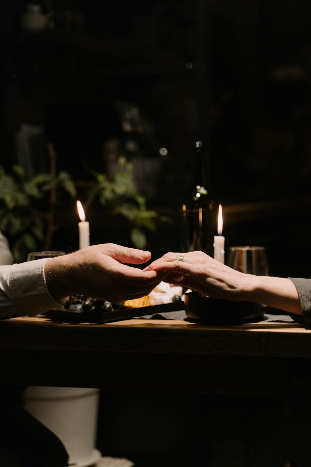 Primer plano de una pareja de la mano en una cena a la luz de las velas | Fuente: Pexels