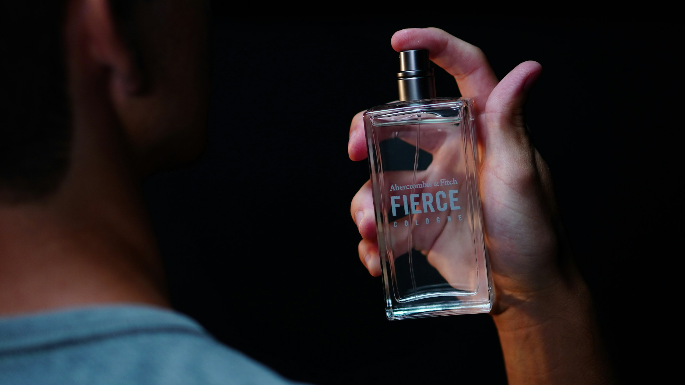 Primer plano de un hombre sujetando un frasco de perfume | Fuente: Unsplash