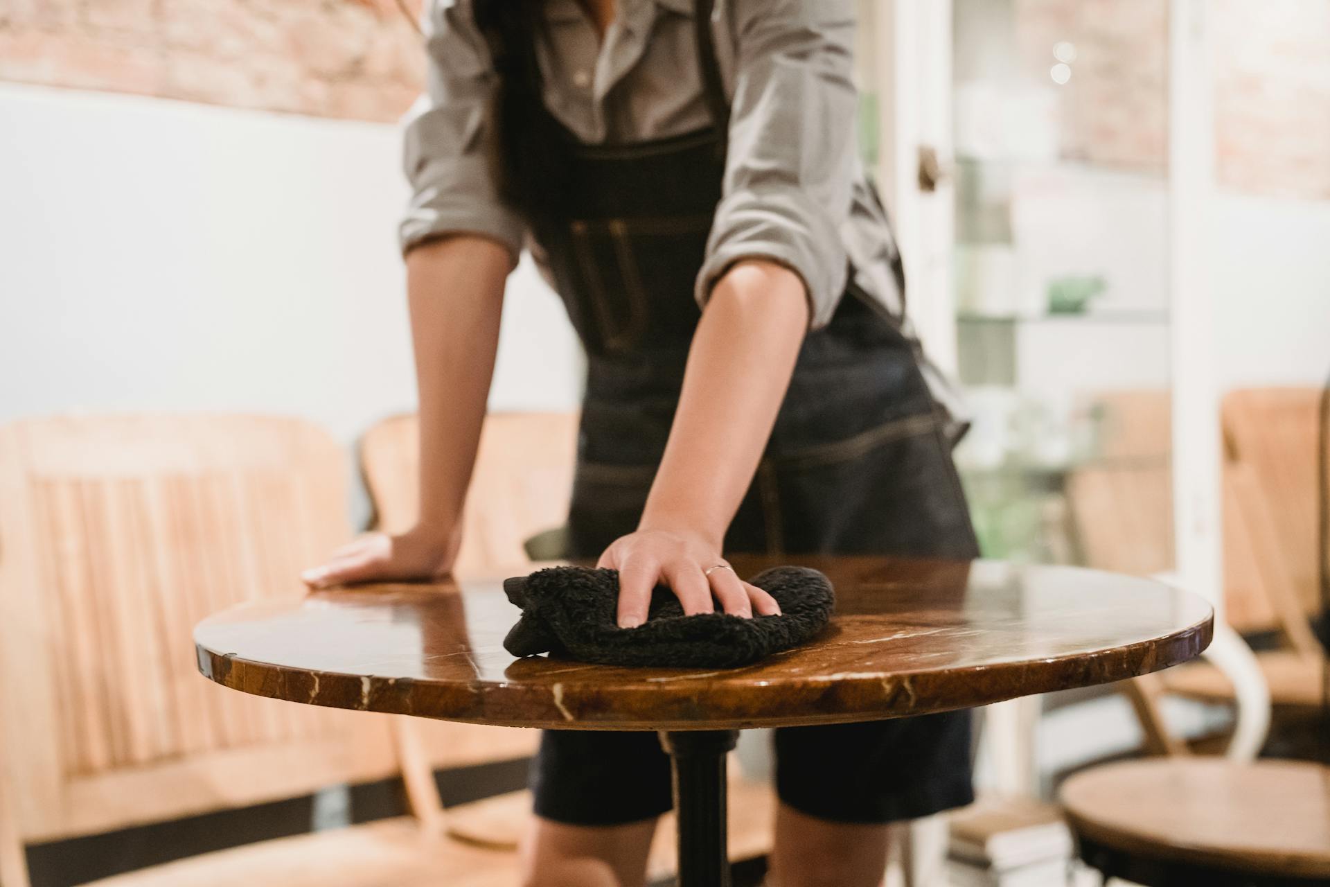 Un hombre limpiando una mesa en un restaurante | Fuente: Pexels
