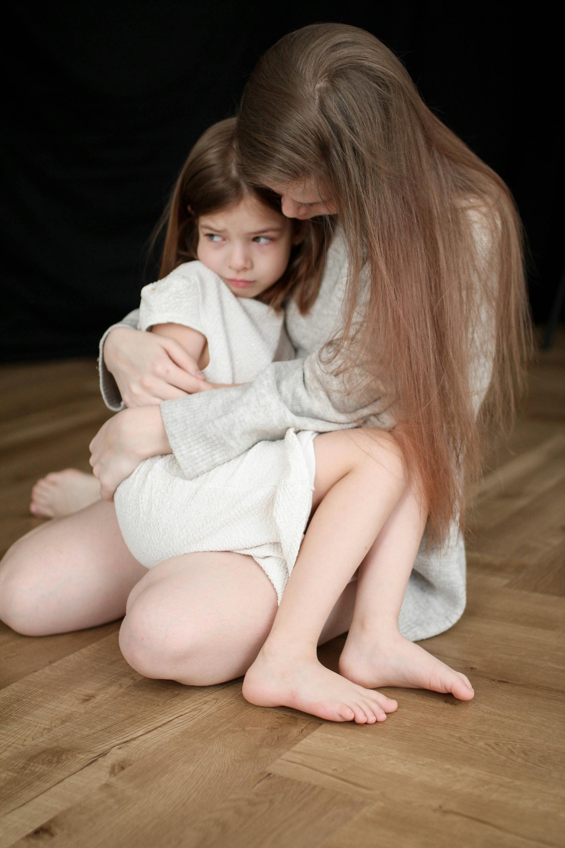 Una mujer sostiene a una niña asustada | Fuente: Pexels