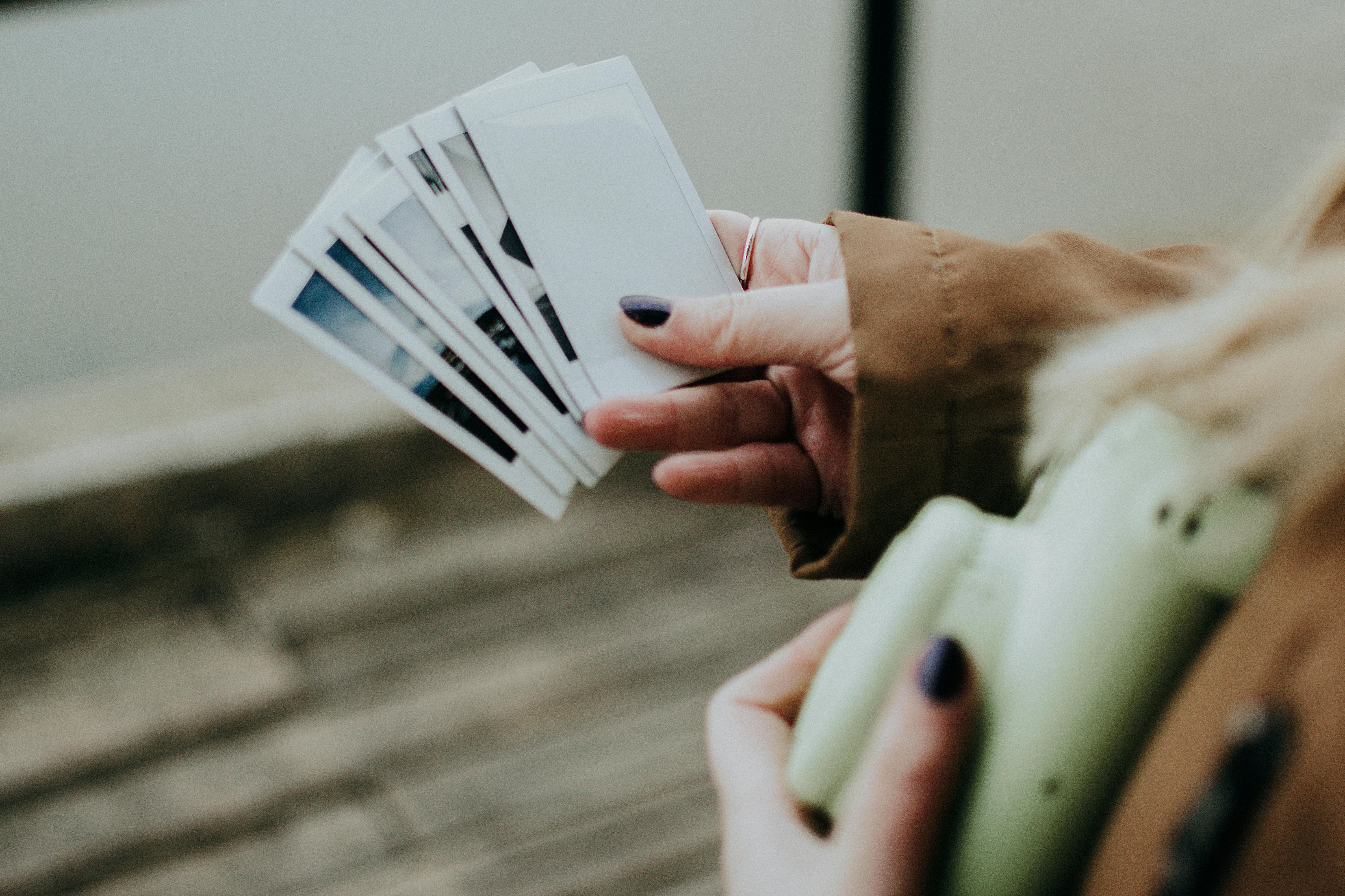 Una persona sosteniendo fotografías | Fuente: Pexels