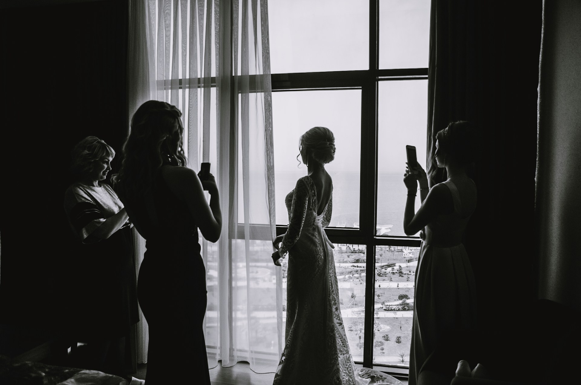 Mujeres haciendo fotos a una novia en su suite | Fuente: Unsplash