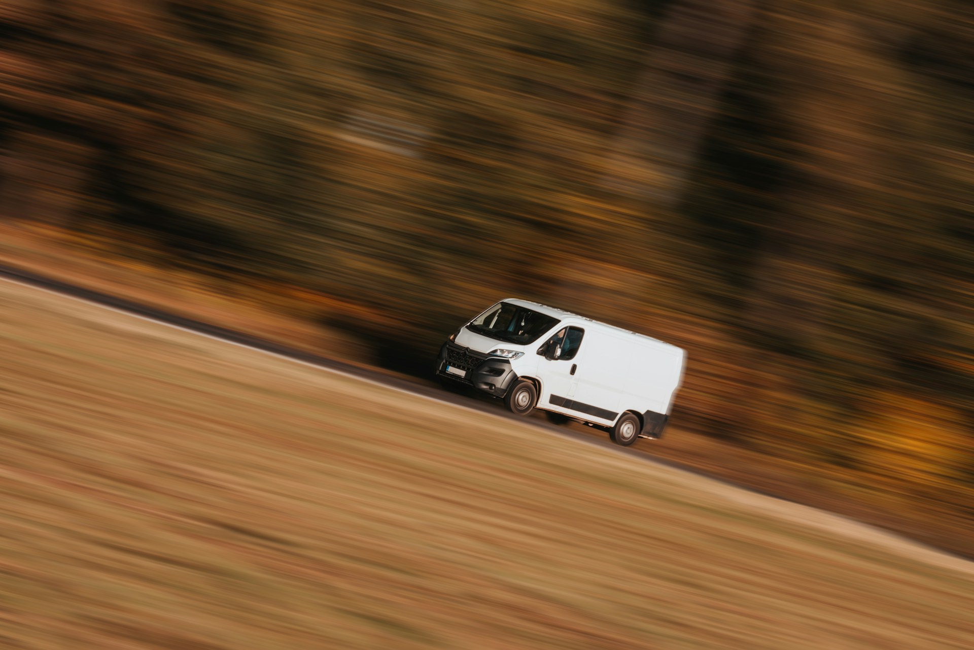 Una furgoneta de reparto circulando a toda velocidad por una carretera | Fuente: Unsplash