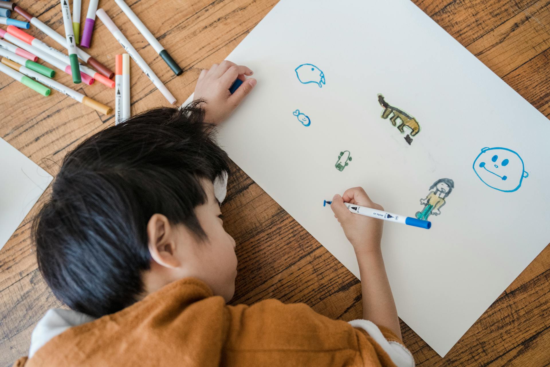 Un niño dibujando en un papel | Fuente: Pexels