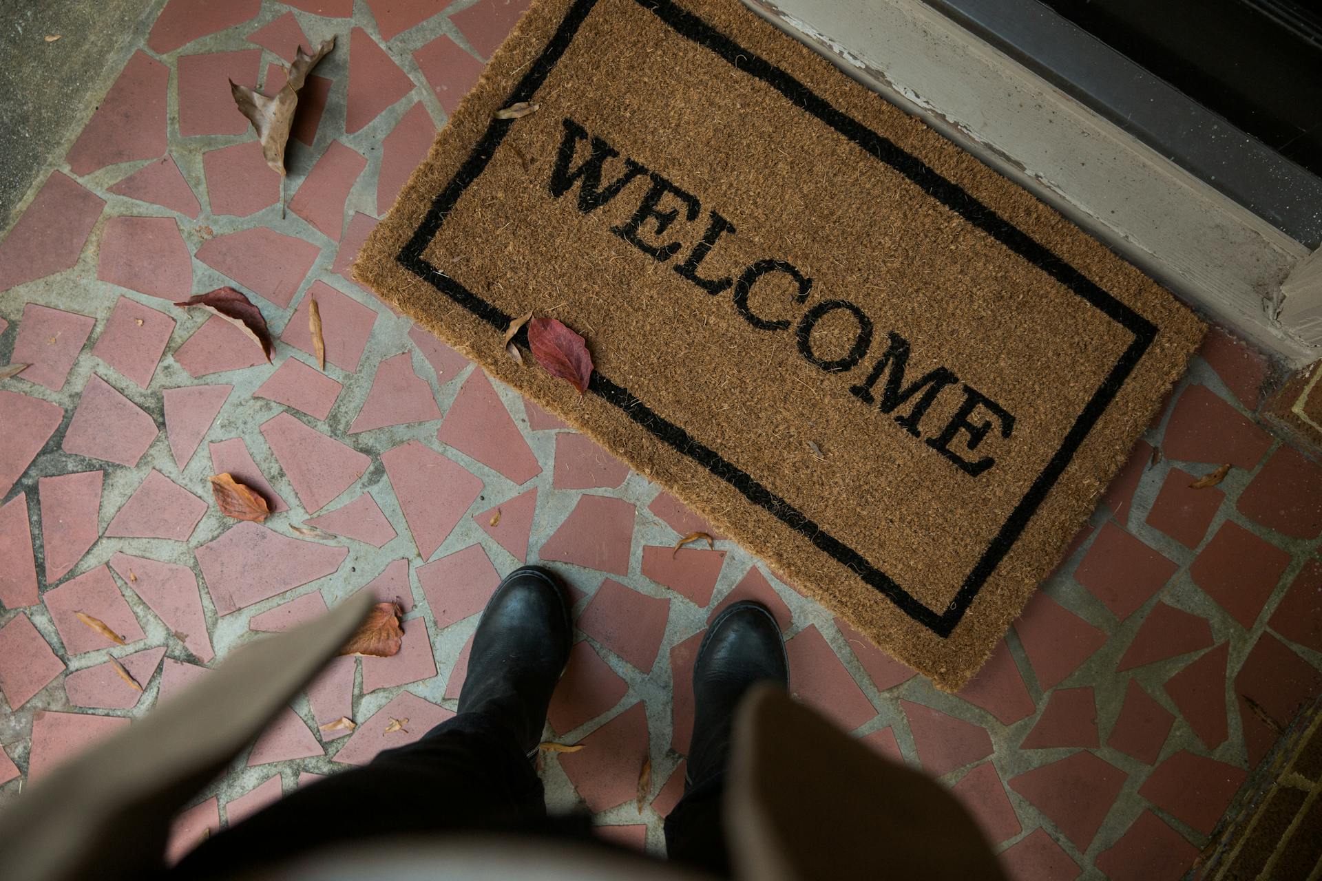 Una persona de pie cerca de un felpudo | Fuente: Pexels