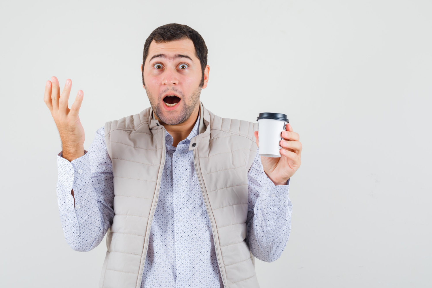 Un hombre conmocionado sujetando una taza de café | Fuente: Freepik